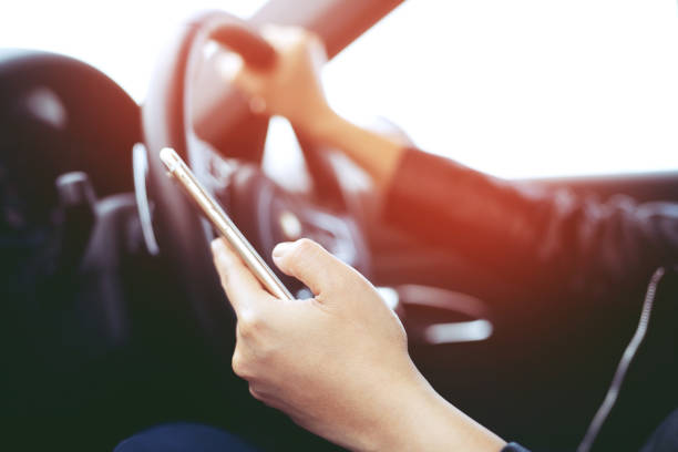 istock Young man driving using mobile smart phone while driving the car. transportation and vehicle concept 1090048426