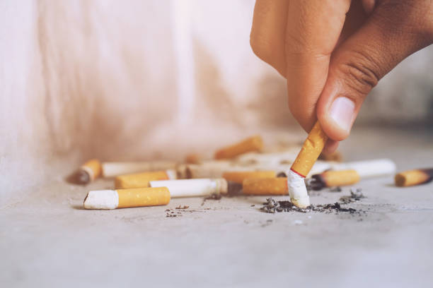 istock Hand putting out a cigarette,cigarette butt on Concrete floor, bare cement. 1090048628