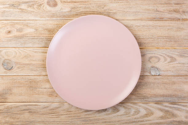 istock Directy above Empty rose matte dish for dinner on orange wooden background 1090049078