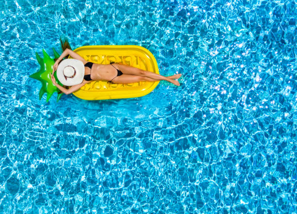 Woman in bikini relaxes on a float in a swimming pool