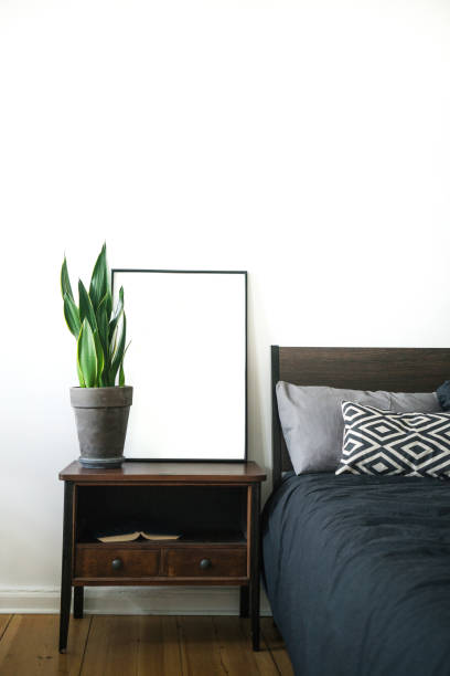 istock Interior poster painting mock up with empty canvas standing on wooden floor, deco element and plant in room with white wall. Interior design photography with copy space 1090054030