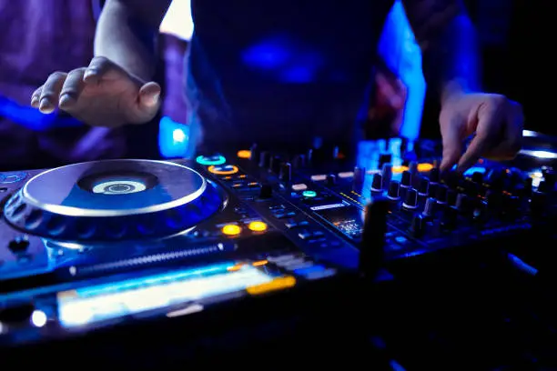 Dj mixes the track in the nightclub at party