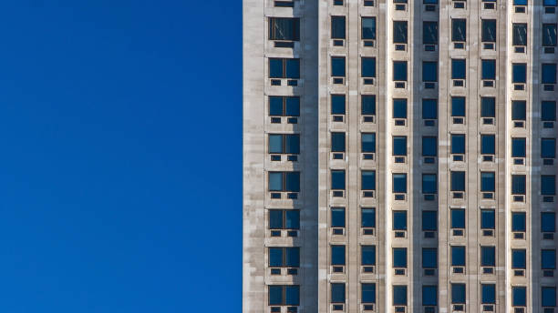 istock Regular pattern made of rectangular windows on block of flats / offices building. Clear sky (place for text) on left side. 1090056034