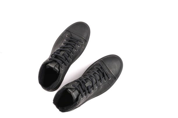 istock men's black leather shoes and a black camera on a black background. Copy space. 1090059870
