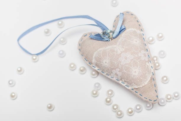 romantic white-blue heart with a stone and a bow close-up on a white background for a greeting card