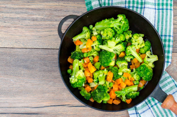istock Vegetarian dish. Broccoli, carrots, green peas in pan 1090083962