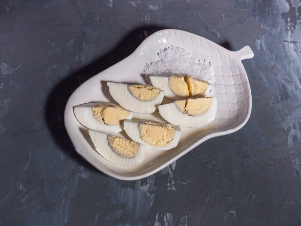 istock Egg sliced on white decorative plate on gray wooden background 1090086128