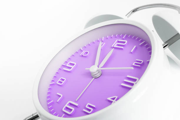 Table alarm clock with time 5 to 12 with purple clock face, 11.55 AM PM, on white background