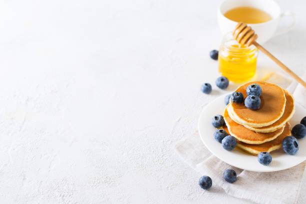 istock Pancakes breakfast, stack of homemade pancakes with blueberries and syrup over white background 1090097782