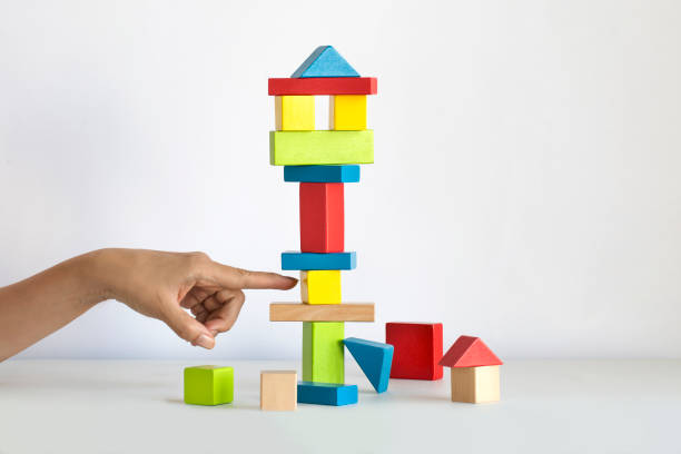 istock Hand trying to demolish a tall stack of cube by removing cube from lower level. 1090099286