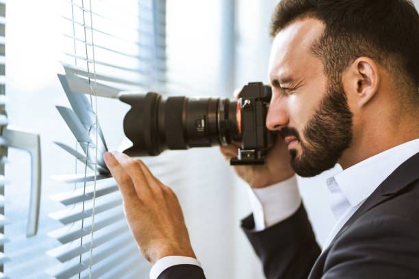istock The man with a camera photographing through the blinds 1090104642