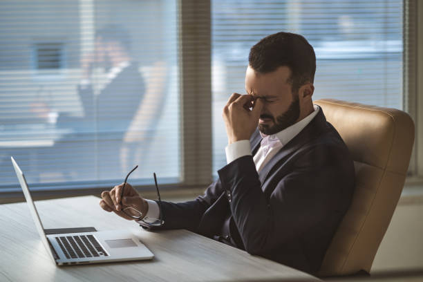 istock The businessman with headache sitting at the table 1090104738