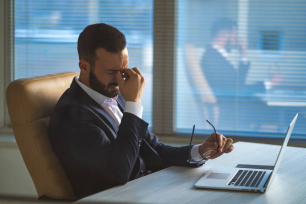 istock The businessman with headache sitting at the table 1090104850