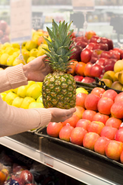 weibliche hand auswahl ananas im store - refrigerator healthy eating mango fruit stock-fotos und bilder