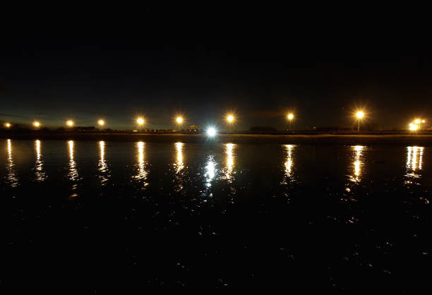 istock Row of lights on the horizon with a reflection in water 1090109966