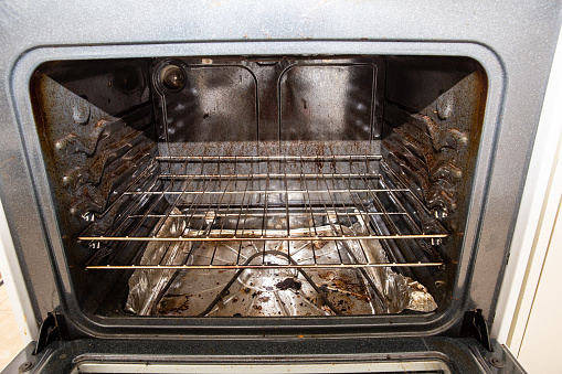 horizontal image of the inside of a very dirty oven in need of a good cleaning.
