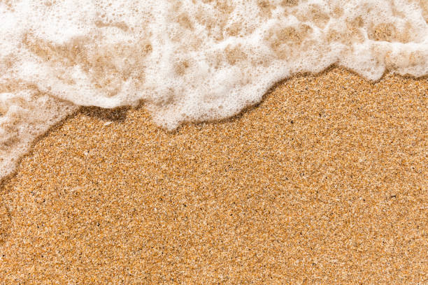 istock Overhead view of clear sand and breaking wave - Vacation Background. 1090113016