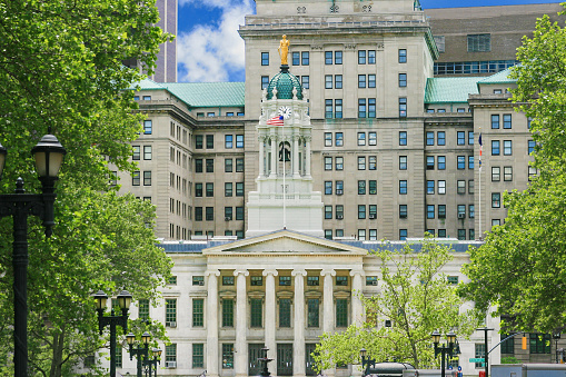 Historic Building that houses Brooklyn (Kings County) Borough Hall, Brooklyn, NY, USA. Green trees and vivid blue sky with clouds are in the image.