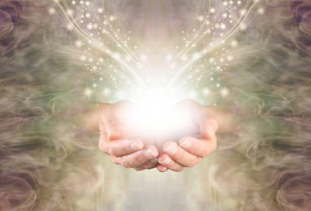Sending You High Resonance Healing Energy female cupped hands emerging from a green gold swirling energy field background with shimmering sparkles and white light flowing outwards reiki photos stock pictures, royalty-free photos & images