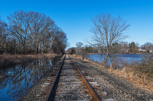 Railroad tracks pass by Manalapan Lake in Middlesex County New Jersey.