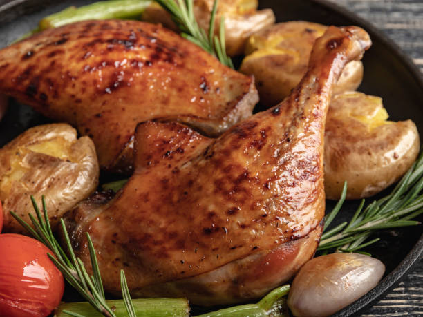 istock Roasted duck legs with potatoes,tomato in a frying pan , black surface, close up 1090134706