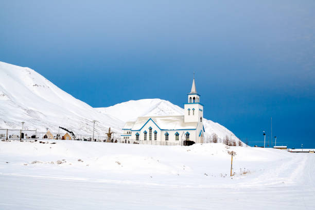 Small white church surrounded by snow in Iceland during Winter.