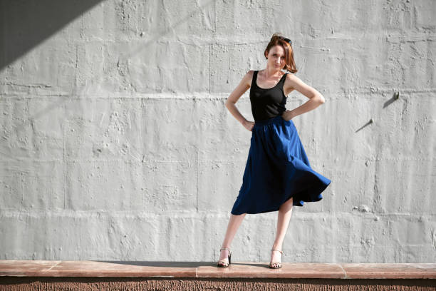 istock young girl posing against a concrete wall, dressed in black, hard light and shadows 1090144744