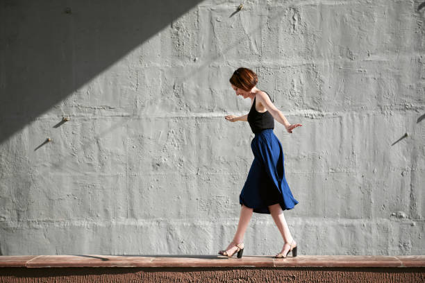 istock young girl posing against a concrete wall, dressed in black, hard light and shadows 1090144766