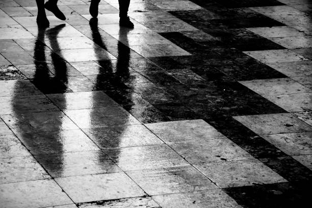 istock Blurry reflection silhouette of two people walking in the rain 1090145086