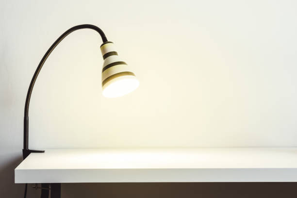 istock Luminous striped lamp on a white table. White wall for mock up or copy space 1090147932