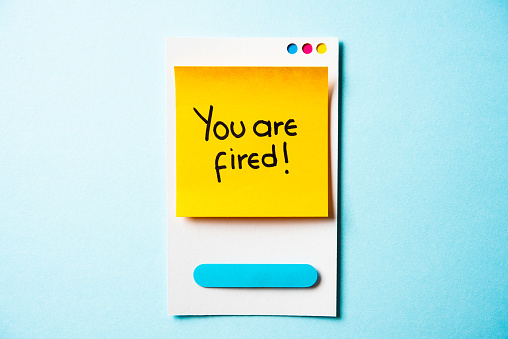 YOU'RE FIRED text with paper smart phone concept on blue background. Paper card with illustration.