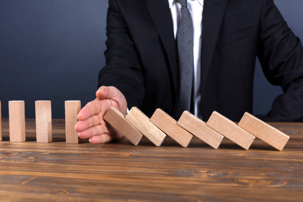 istock Businessman hand stop domino effect 1090164852
