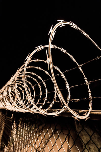 istock Sharp Razor wire, keep out, no trespassing close-up with detail. Chainlink fence. 1090182998