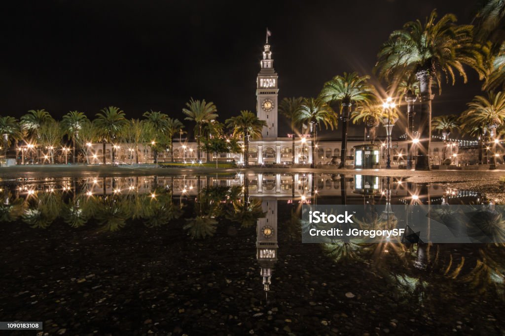 Night reflection of Ferry Building and palm trees in San Francisco. Rain Stock Photo