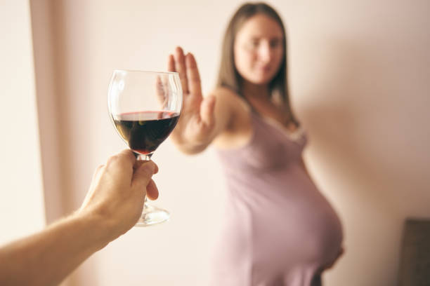 selective focus of wine and pregnant woman refusing it - abdomen women loving human hand imagens e fotografias de stock