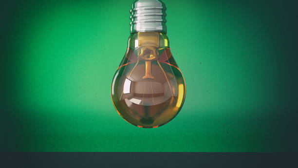 istock Orange light bulb on a green background with copy space 1090188294