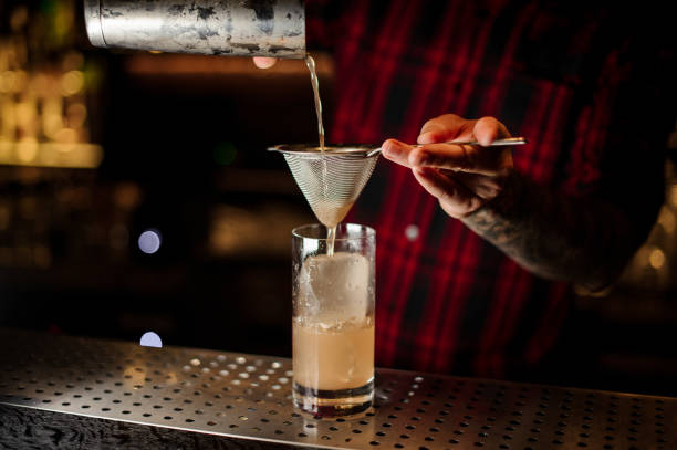 istock Bartender pouring a Lemonade cocktail from the steel shaker through the strainer 1090196734