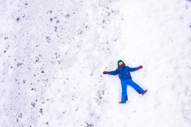istock Young boy lying on the snow. Aerial view. 1090201114