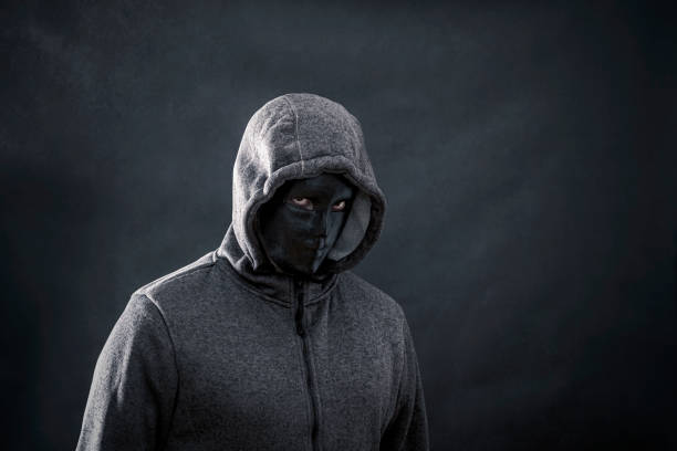 istock Hooded man with black mask in the dark 1090201206