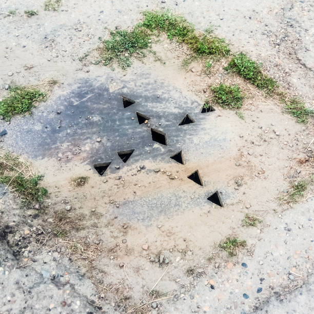 istock The drain hatch, amid the asphalt hatch with holes. 1090209952