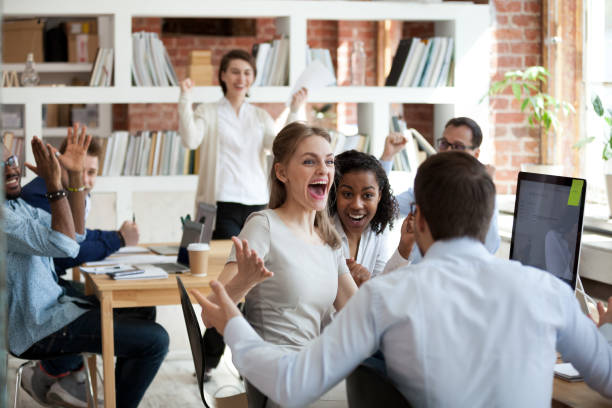 excited diverse business team employees screaming celebrating good news success - team work celebrating imagens e fotografias de stock