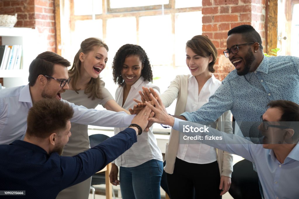 Happy diverse colleagues give high five together celebrate great teamwork Happy diverse colleagues team people give high five together celebrate great teamwork result motivated by business success victory loyalty unity concept, good corporate relations and teambuilding Teamwork Stock Photo