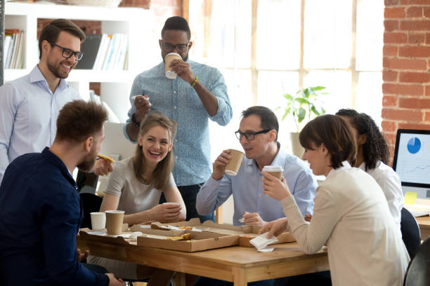 wieloetniczna grupa pracowników lubi rozmawiać w biurze z jedzeniem na wynos - coffee time zdjęcia i obrazy z banku zdjęć