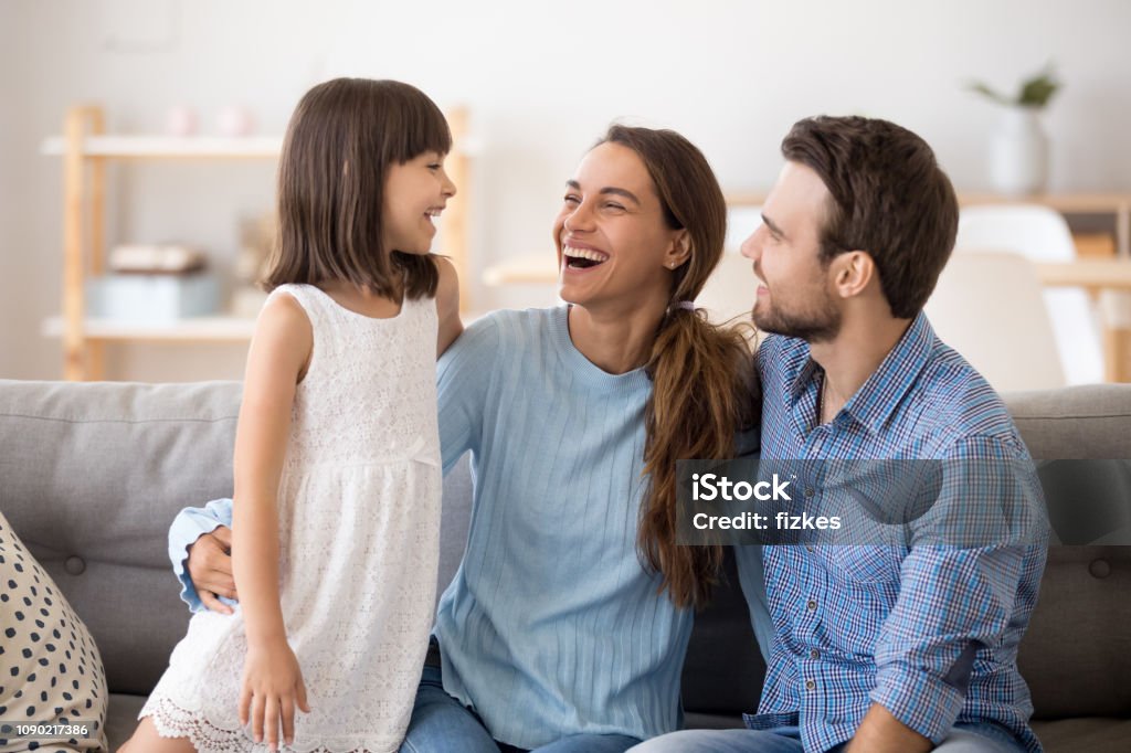Hija de niños que se divierten hablando con padres felices riendo juntos - Foto de stock de Familia libre de derechos