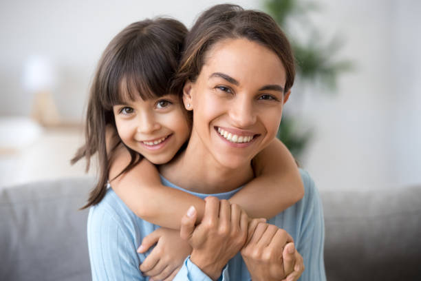 istock Happy mom and cute kid daughter embracing looking at camera 1090217396