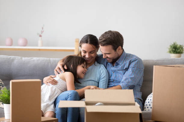 istock Happy parents with kid embracing on sofa enjoy moving day 1090217526