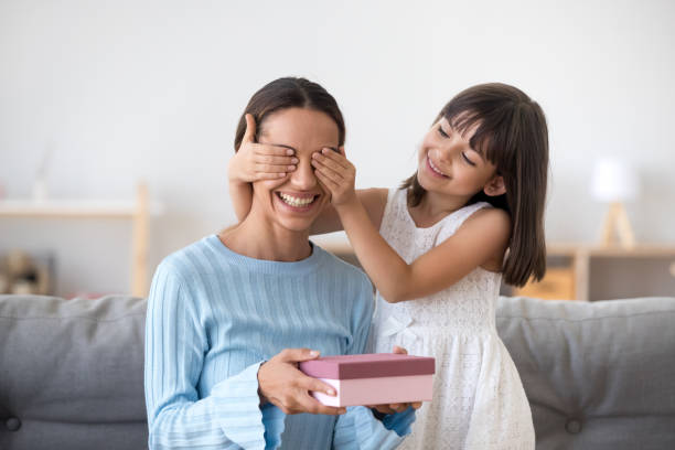 uśmiechnięta córka dziecka zamykająca oczy mamy gratulując z dnia matki - birthday present family facial expression birthday zdjęcia i obrazy z banku zdjęć