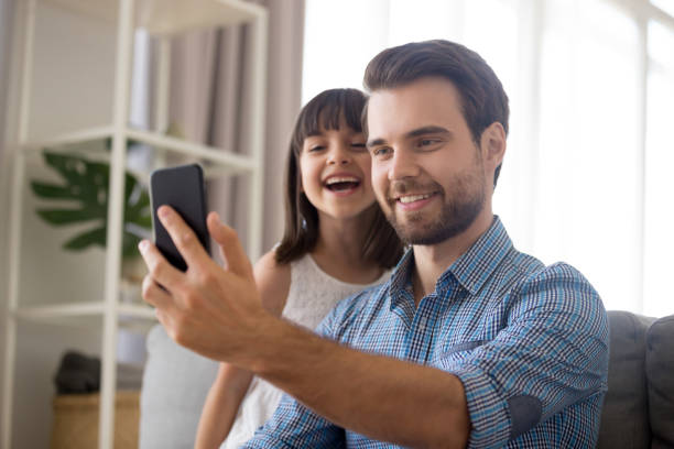 istock Smiling father taking selfie with cute kid daughter on smartphone 1090217604