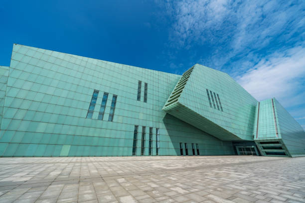 M+ Museum in West Kowloon cultural district in Hong Kong  - october 10, 2025 : The M+ building stands by a harbour, its central tower flanked by garden-lined. M+ is Asia's global museum of contemporary visual culture.