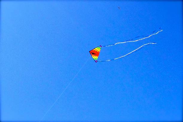 un cerf-volant vole haut dans le ciel bleu - beach 2013 usa sky photos et images de collection